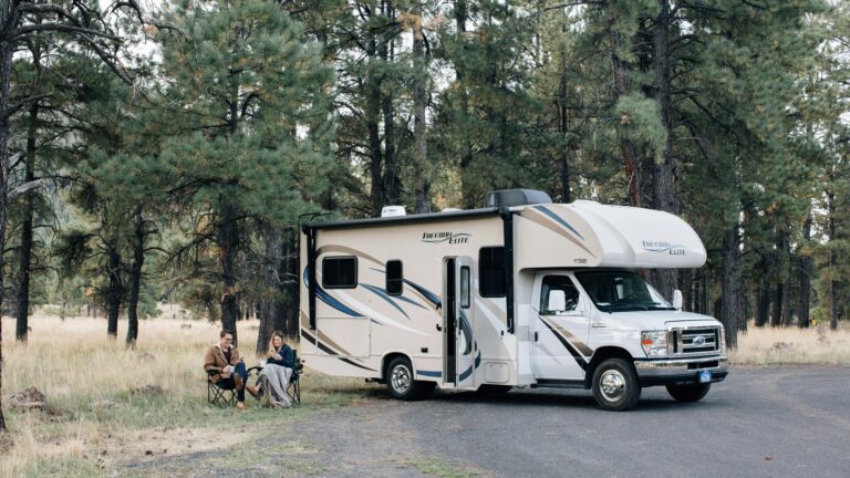 Two people sitting outside of an RV, discussing rental RV income