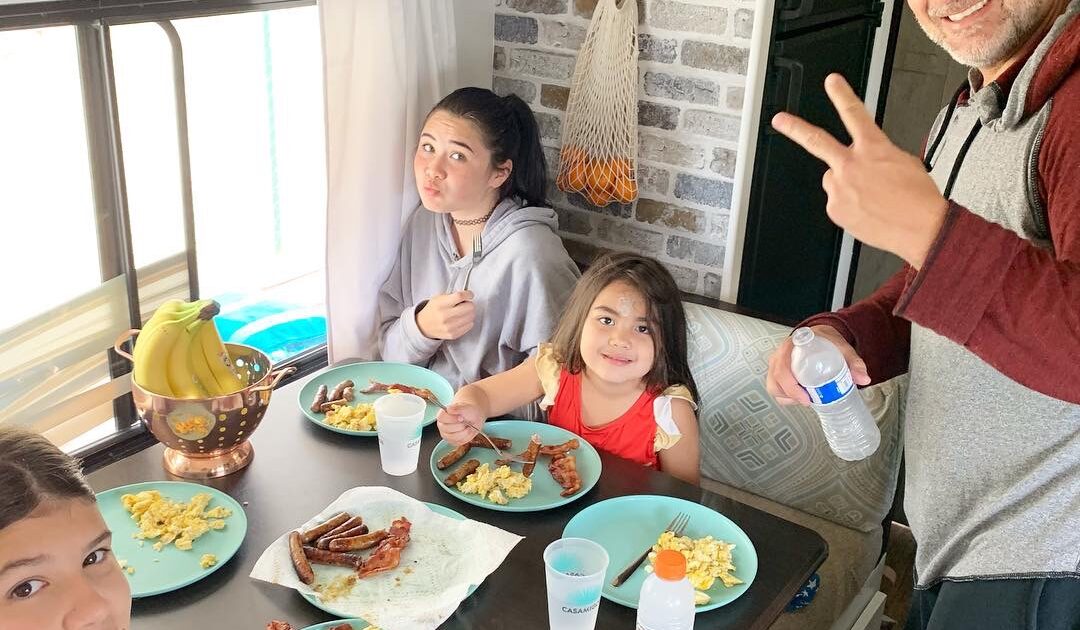 family enjoying breakfast in an RV kitchen