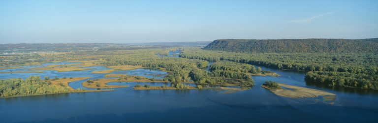 A river with several grassy, forested islands in Pikes Peak State Park, Iowa.