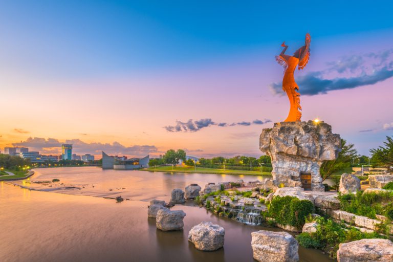 WICHITA, KANSAS - AUGUS 31, 2018: Downtown Wichita at dawn from the Arkansas River and Keeper of the Plains.