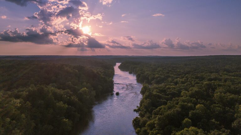 River running through a forest against a blue and pink sky, something you might see while North Carolina boondocking