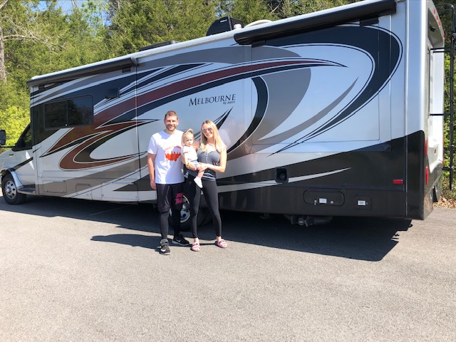 Family standing in front of a Class C RV