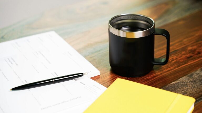 Paperwork for forming an LLC for an RV rental business sitting next to a mug of coffee