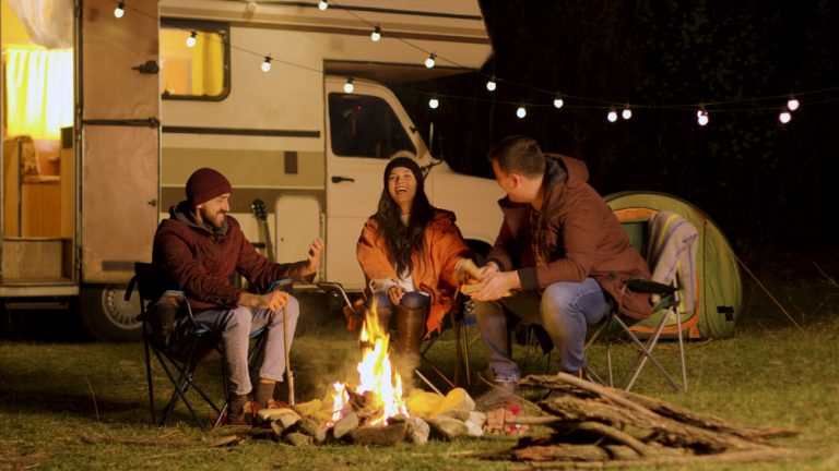 Group,Of,Close,Friends,Laughing,Together,Around,Camp,Fire.,Retro