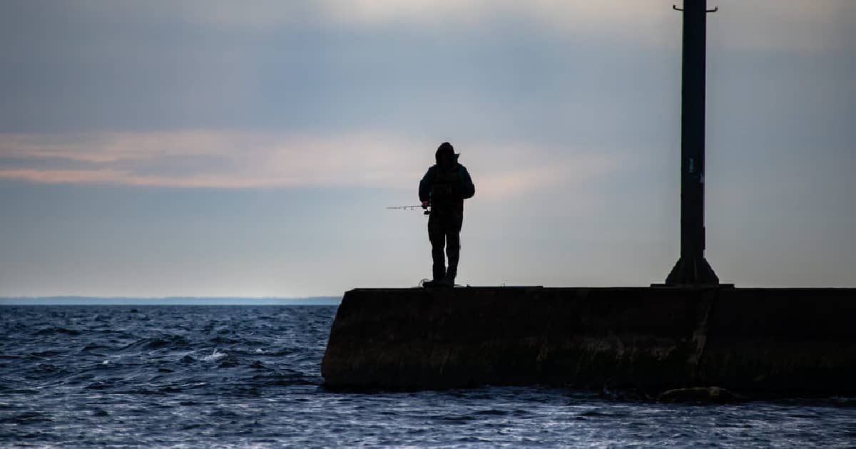 a person on a jetty with a pole doing some fishing in Michigan