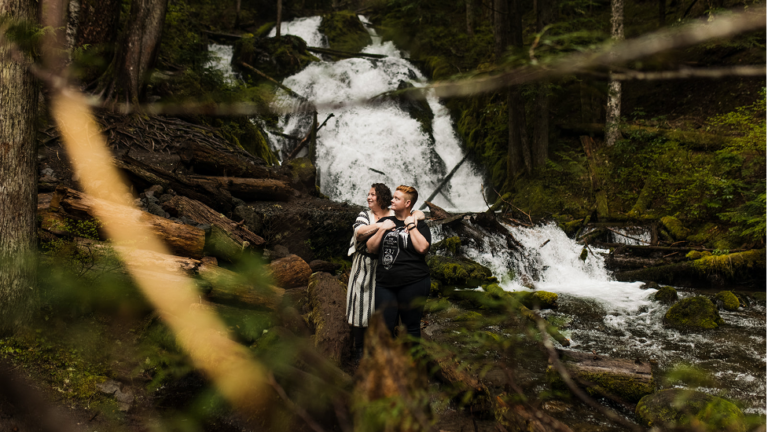 couple embraces at zigzag falls in oregon