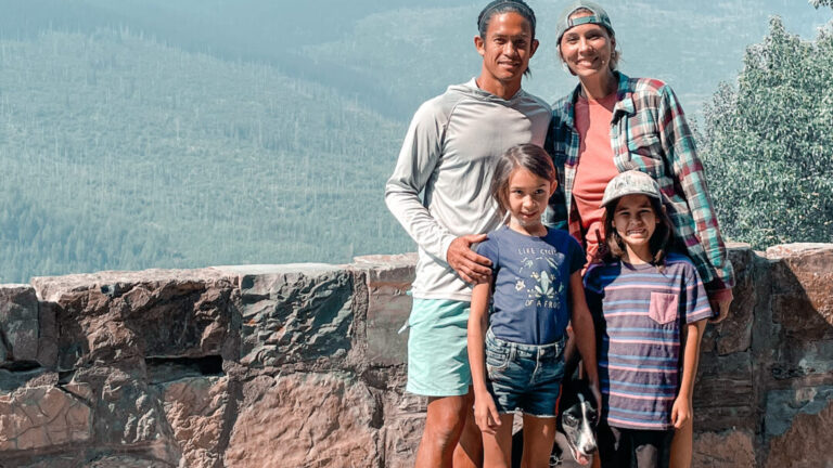 Family of four - mom, dad, son, daughter - poses at Glacier National Park
