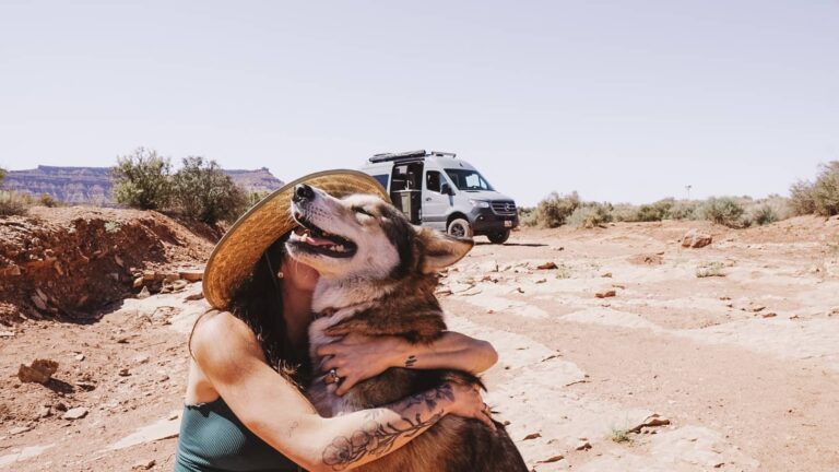 Lady hugging her dog in a pet-friendly campground in front of a campervan