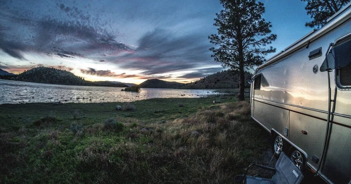 Airstream trailer sitting in front of a lake at a long term RV park