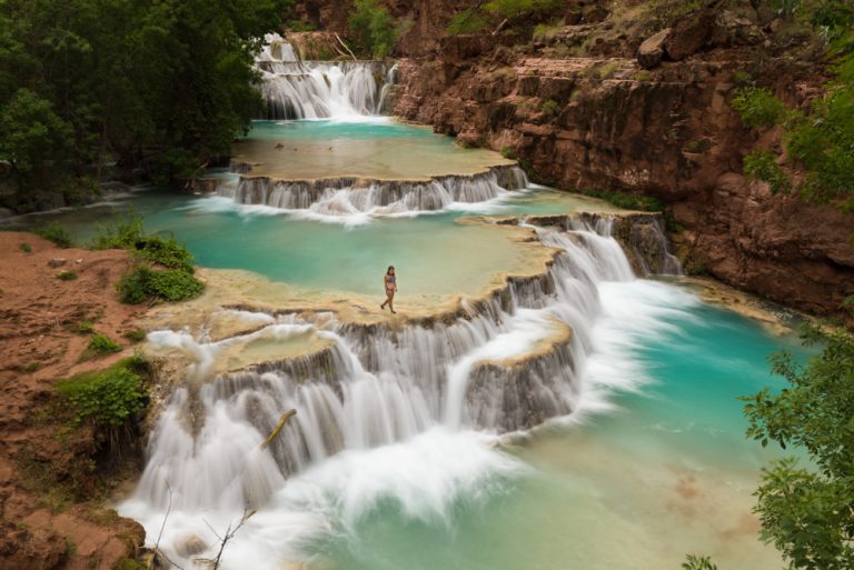 Woman walking along Beaver Falls in Havasupai reservation, Arizona