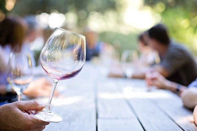 an almost empty wineglass being held at a table