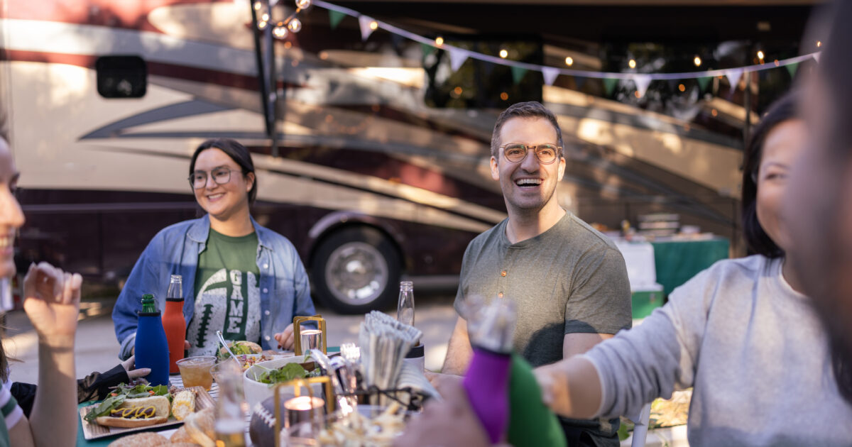 group of friends tailgating next to an RV