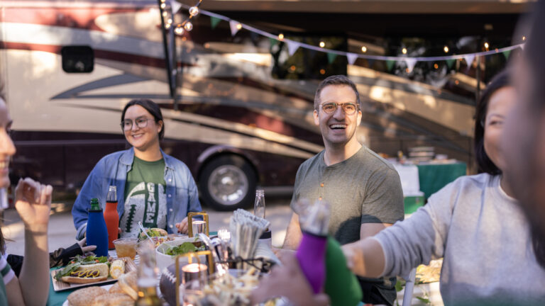 group of friends tailgating next to an RV