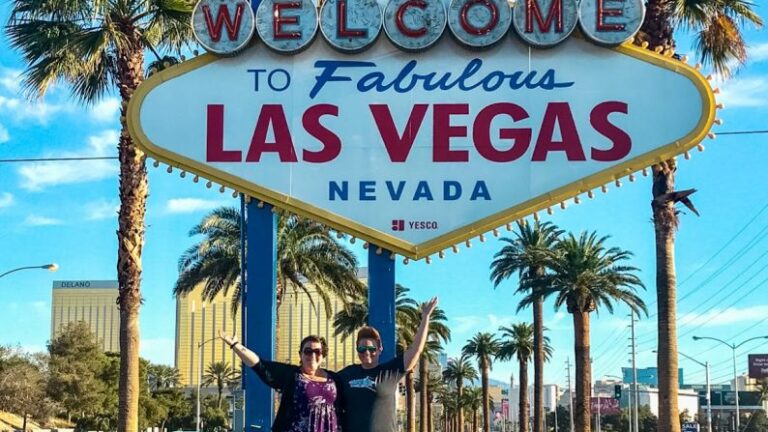 Couple poses in front of Welcome to Las Vegas sign