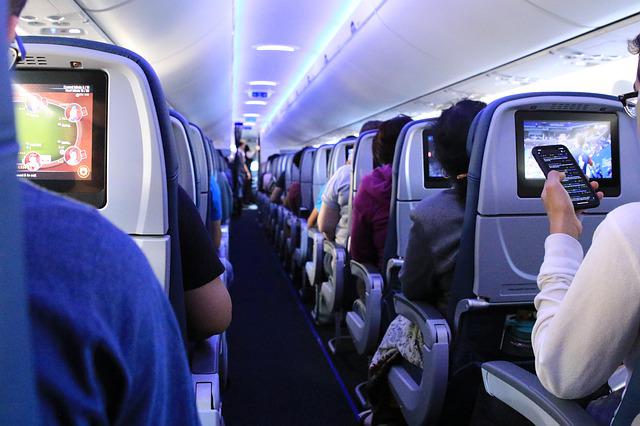 people on an airplane watching the in flight movie