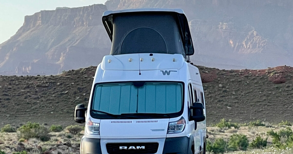 a Class B campervan parked at a rocky campsite
