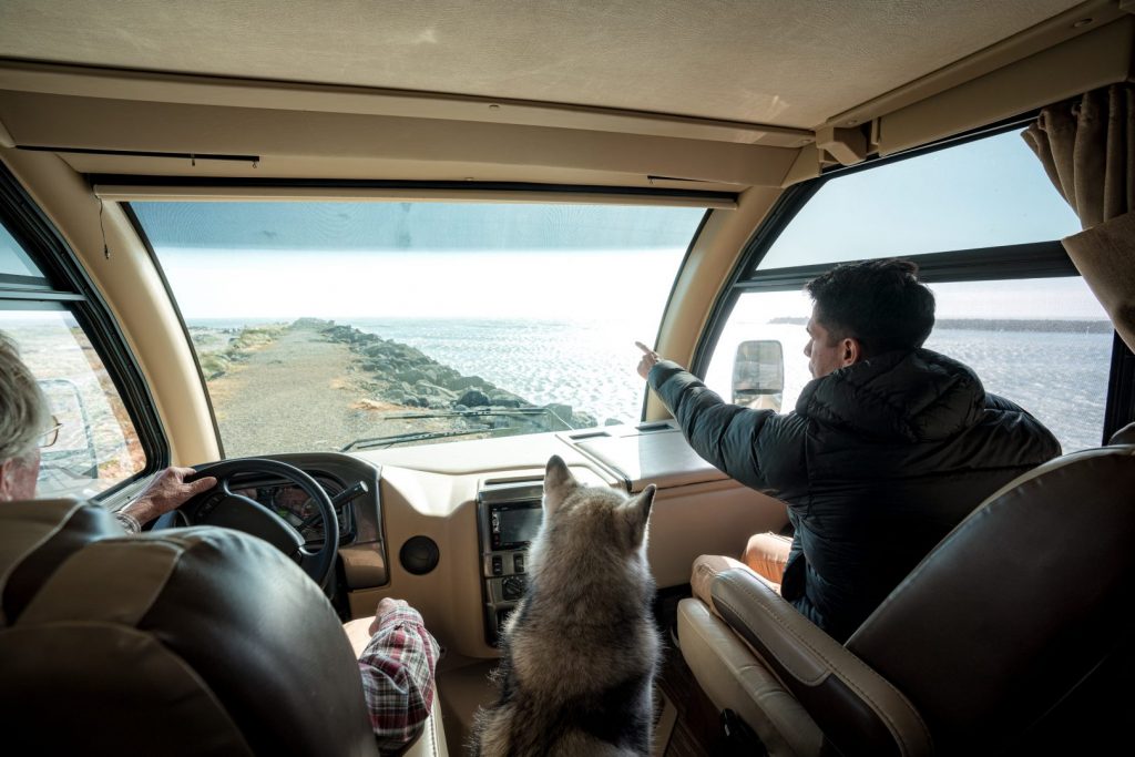 man points out towards the windshield of his rv