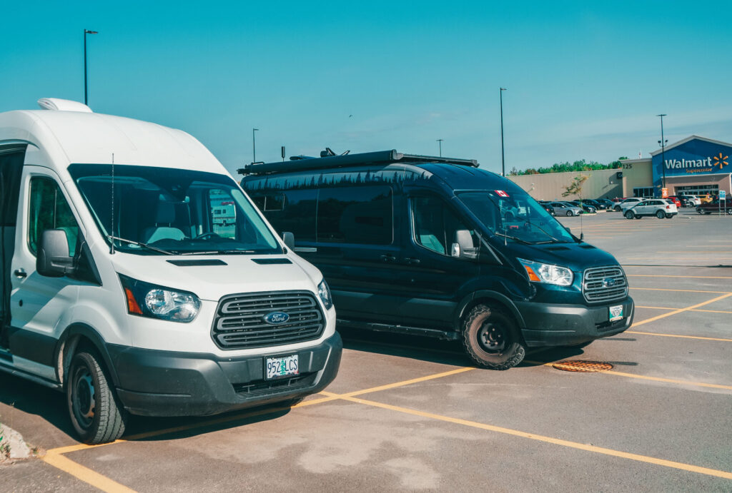 Two camper vans parked next to each other in a parking lot