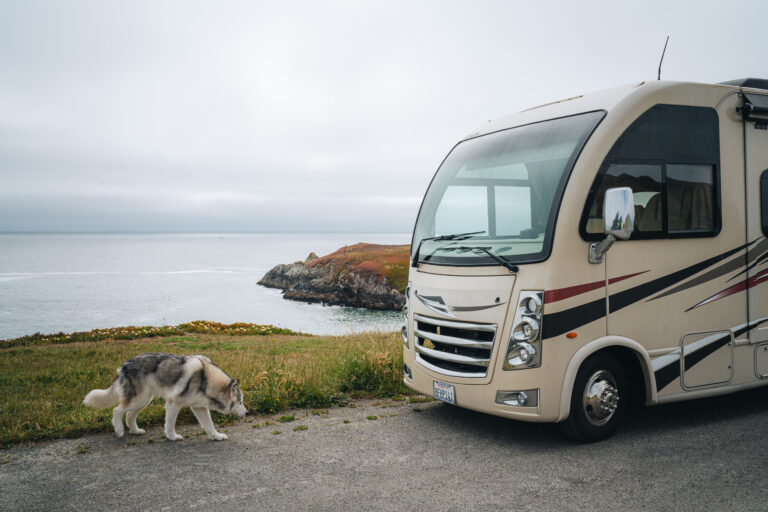 an RV parked by the sea with fog rolling in