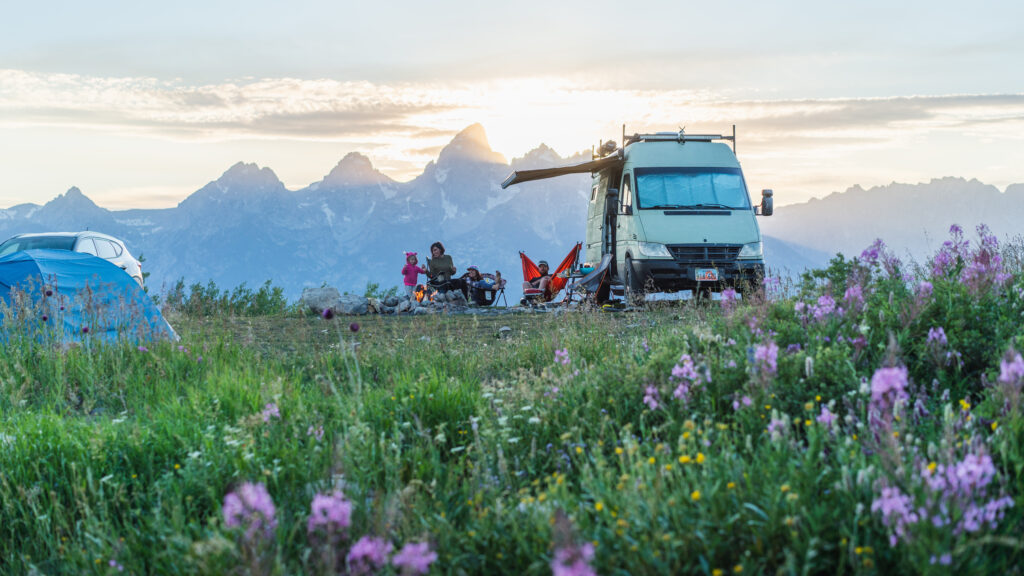 An RV in the mountains with an awning up