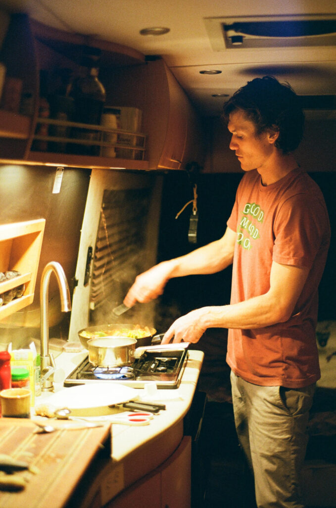 man cooking in an RV kitchen with RV lighting