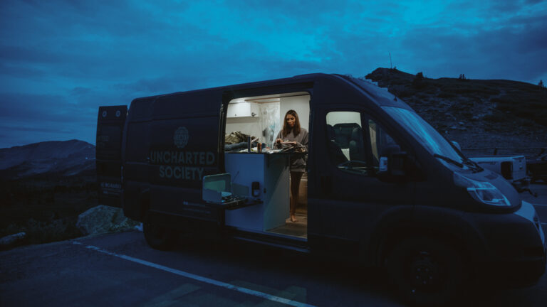 campervan in dark parking spot, lit up inside