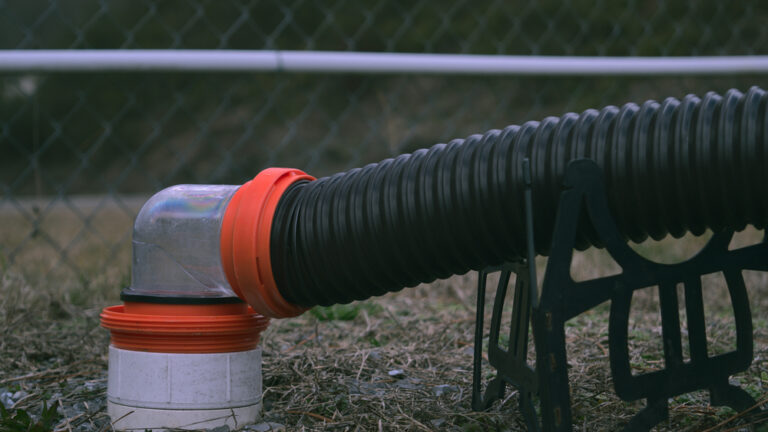 An RV sewer hose connected to the drain