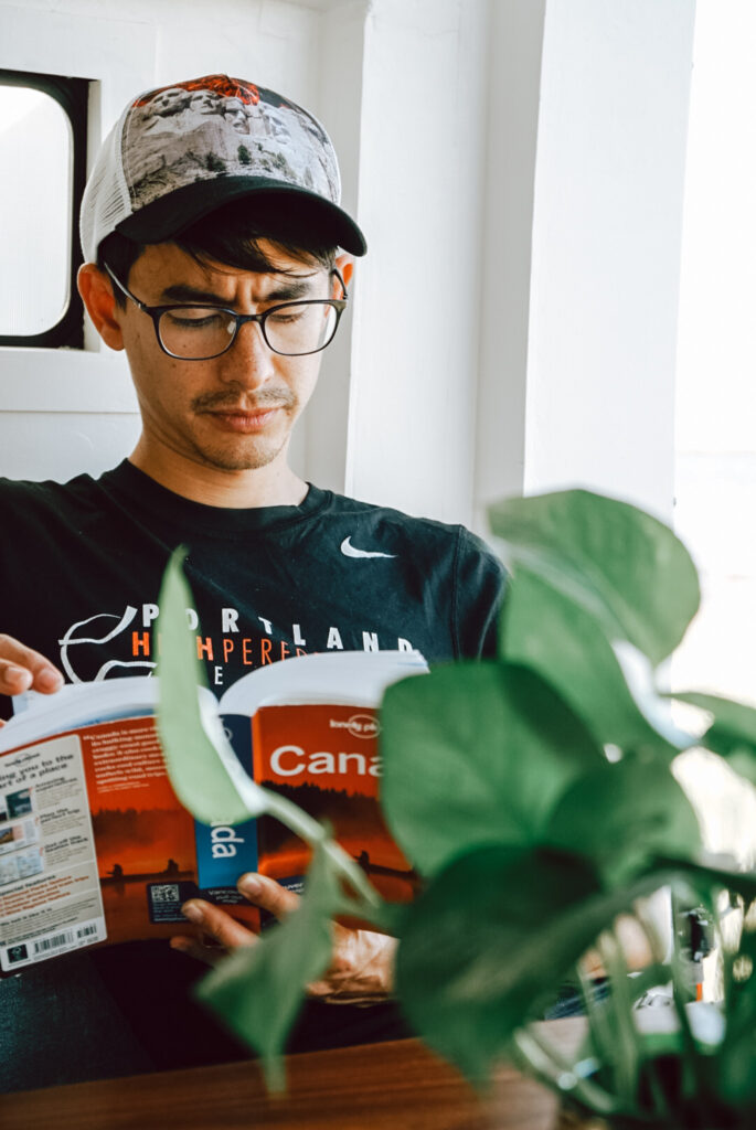 man studies Canadian travel guide book