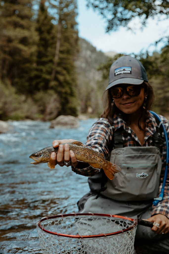 woman standing in water holding a fish