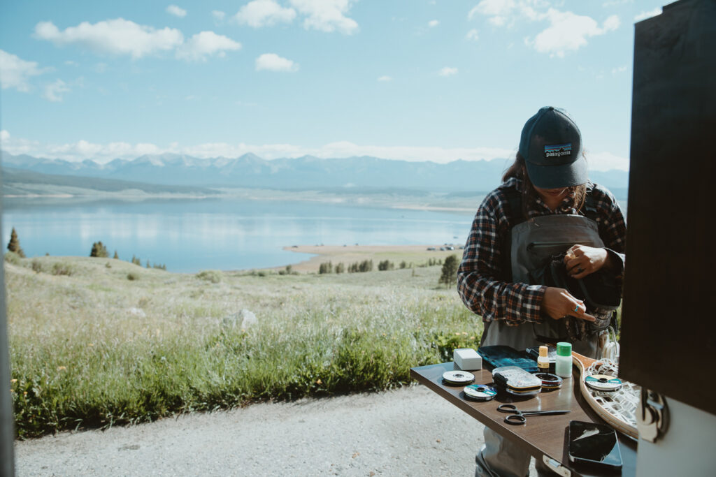 soman standing at rv table with water in the background