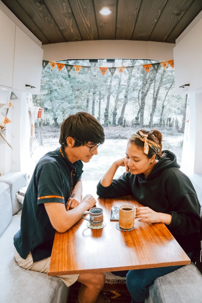 couple sitting at a table looking at a phone together