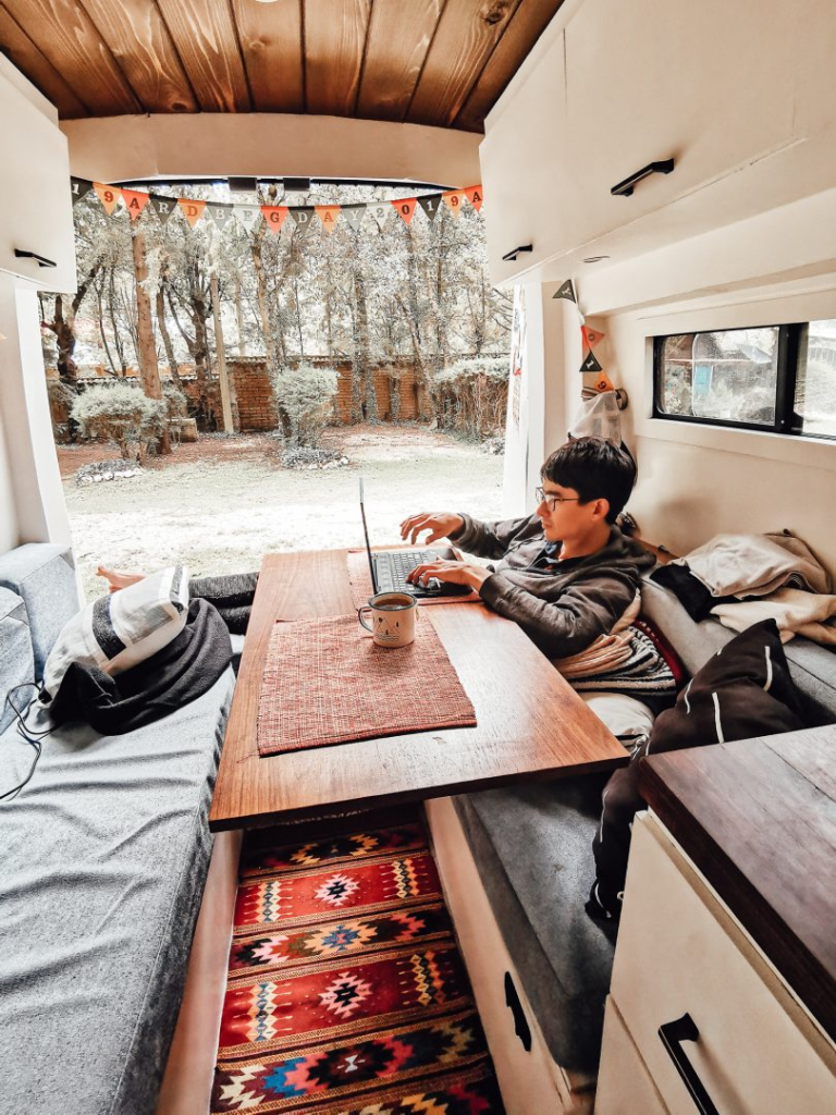 man sitting at a table in his rv with the back door open