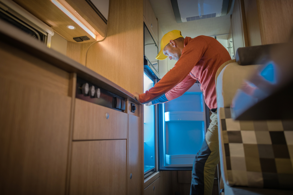 a man maintaining an RV fridge