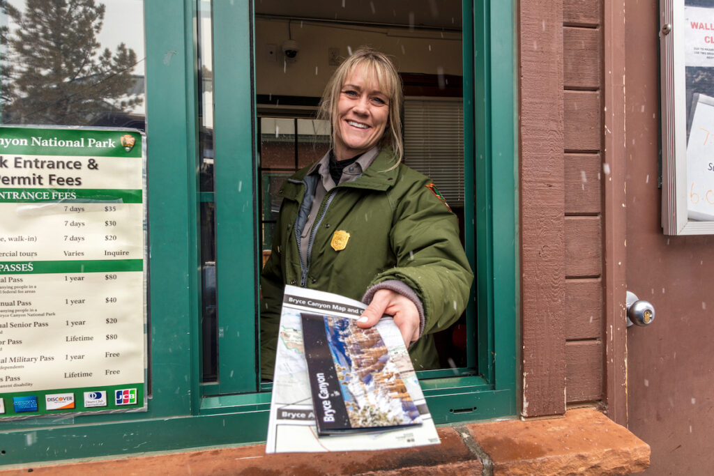 National Park toll worker passes fliers out the window