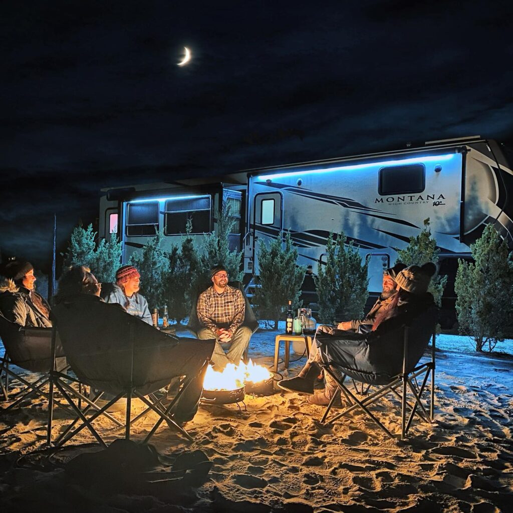 people having a campfire with an RV behind