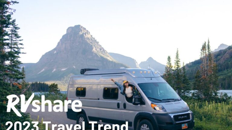 woman hanging out of a camper van with mountain in the distance