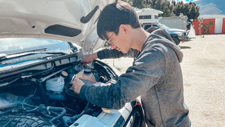Man repairs engine of his camper van