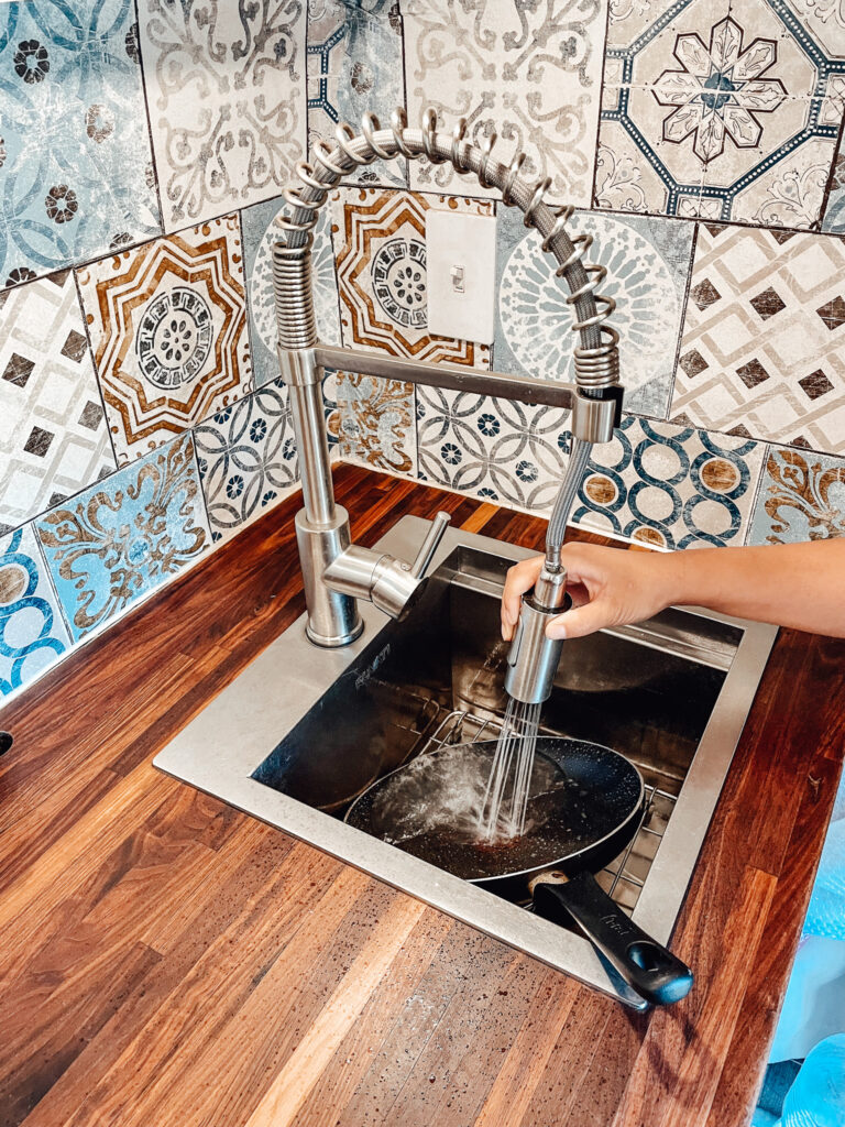 Kitchen sink with tile backsplash of camper van