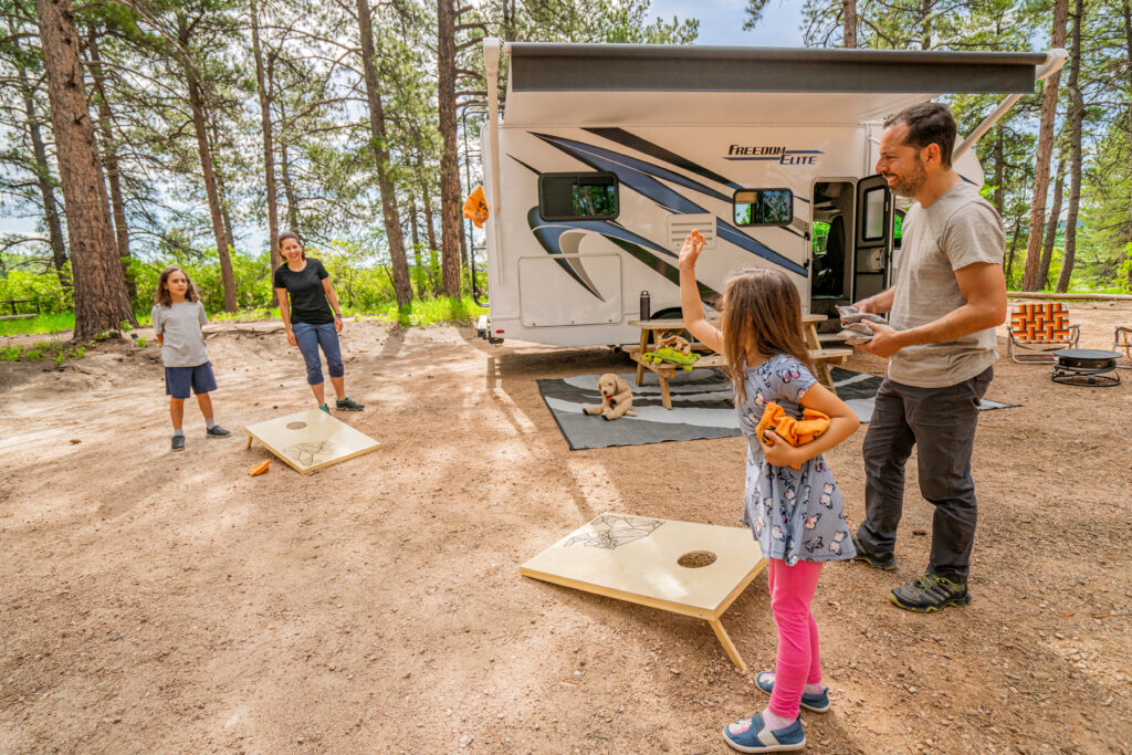 family playing yard games in front of an rv