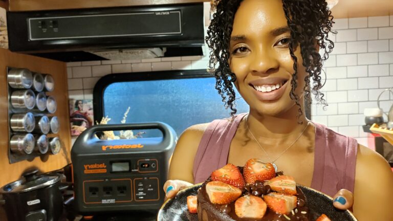 Woman holds Homemade brownie topped with strawberries
