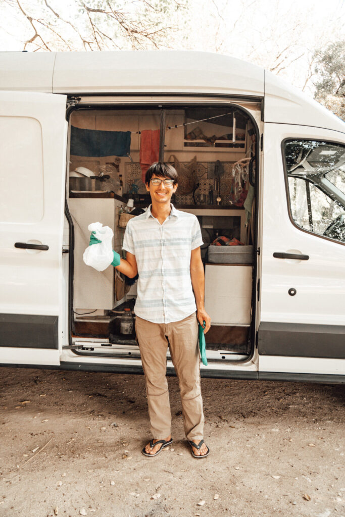 man outside campervan collecting trash