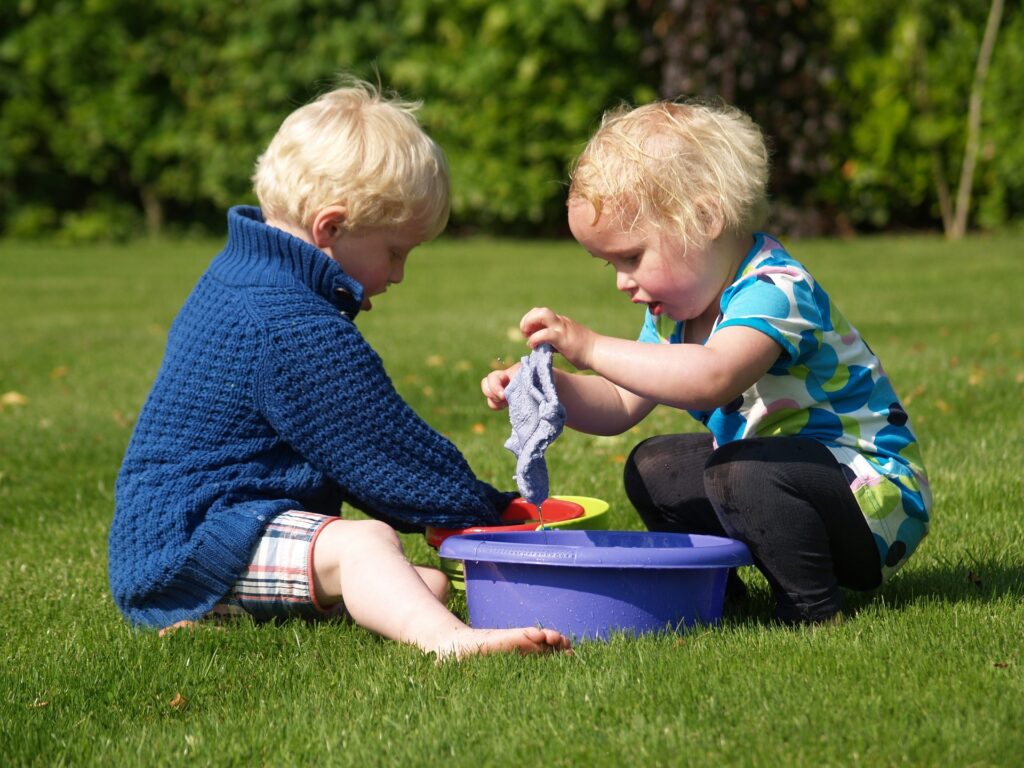 Toddlers help clean up campsite