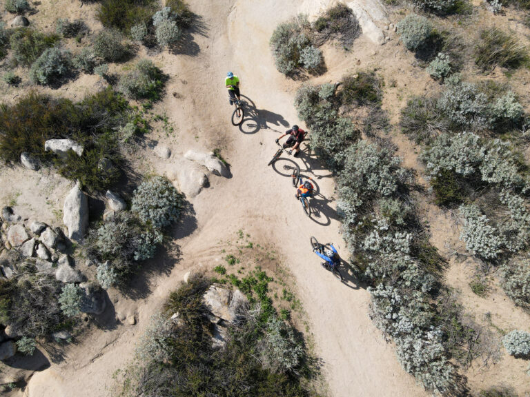 Aerial view of mountain bikers in small dry trails in the mountain, California, USA