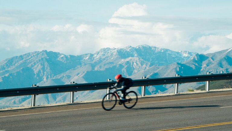 Mountain biker going down the road with mountains in the background in Salt Lake City, Utah, USA