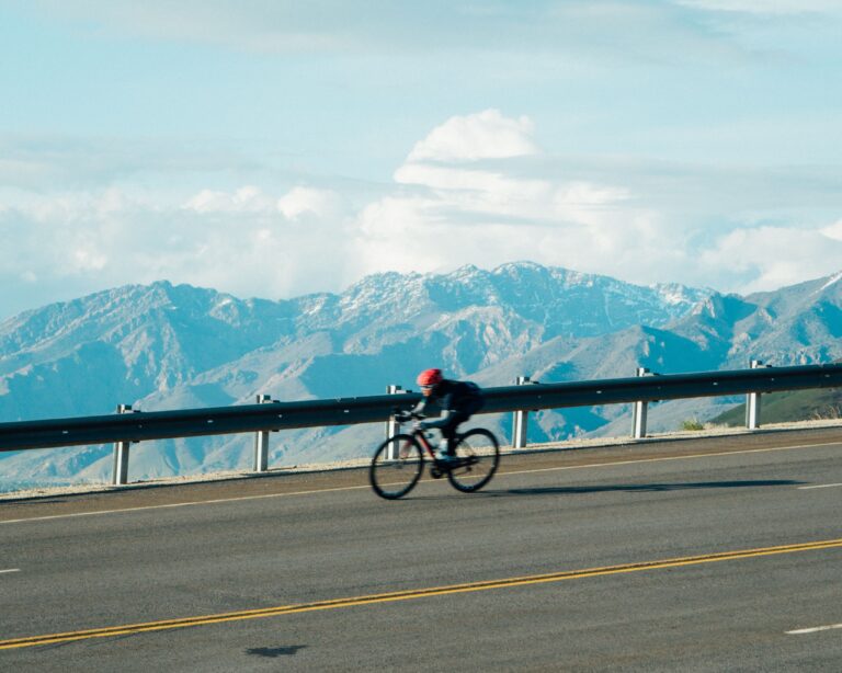 Mountain biker going down the road with mountains in the background in Salt Lake City, Utah, USA