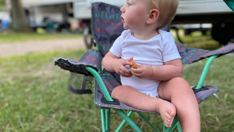 Baby sitting in front of an RV