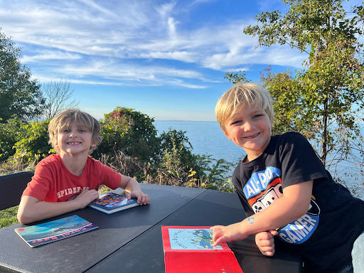 two kids outside using notebooks