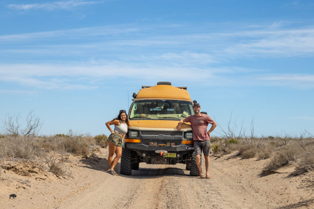 couple standing in front of van off-road