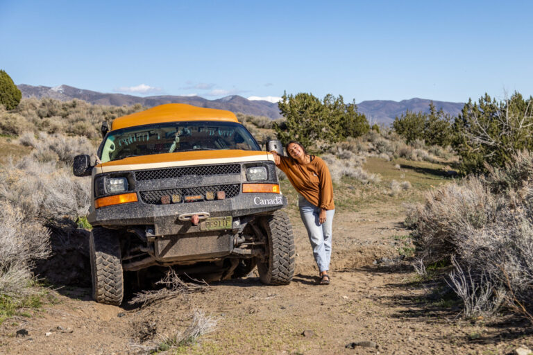 woman standing outside stuck van using recovery gear