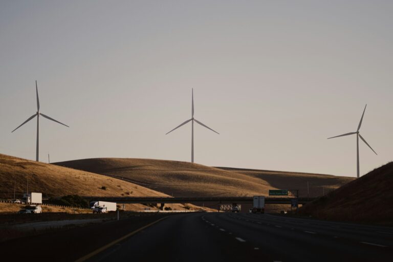 3 windmills stand tall over the road to Stockton, CA